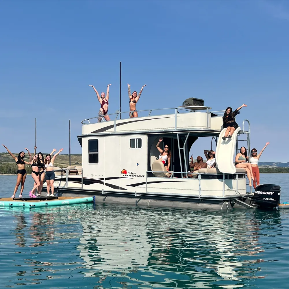 Guests waving from both decks of the boat beside the floating dock
