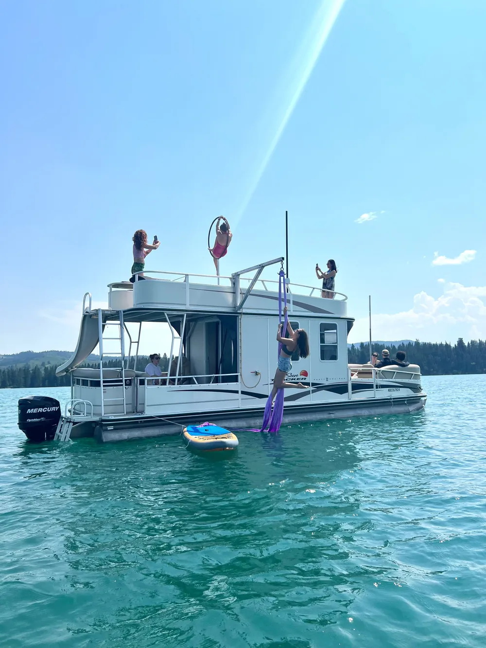 A guest coming down the boat's water slide into the lake