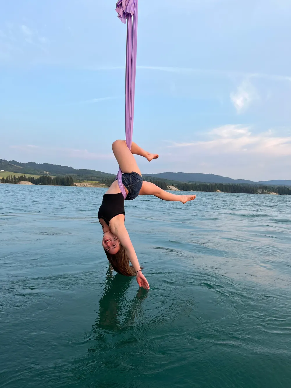 A dancer on the pole with her feet in the lake